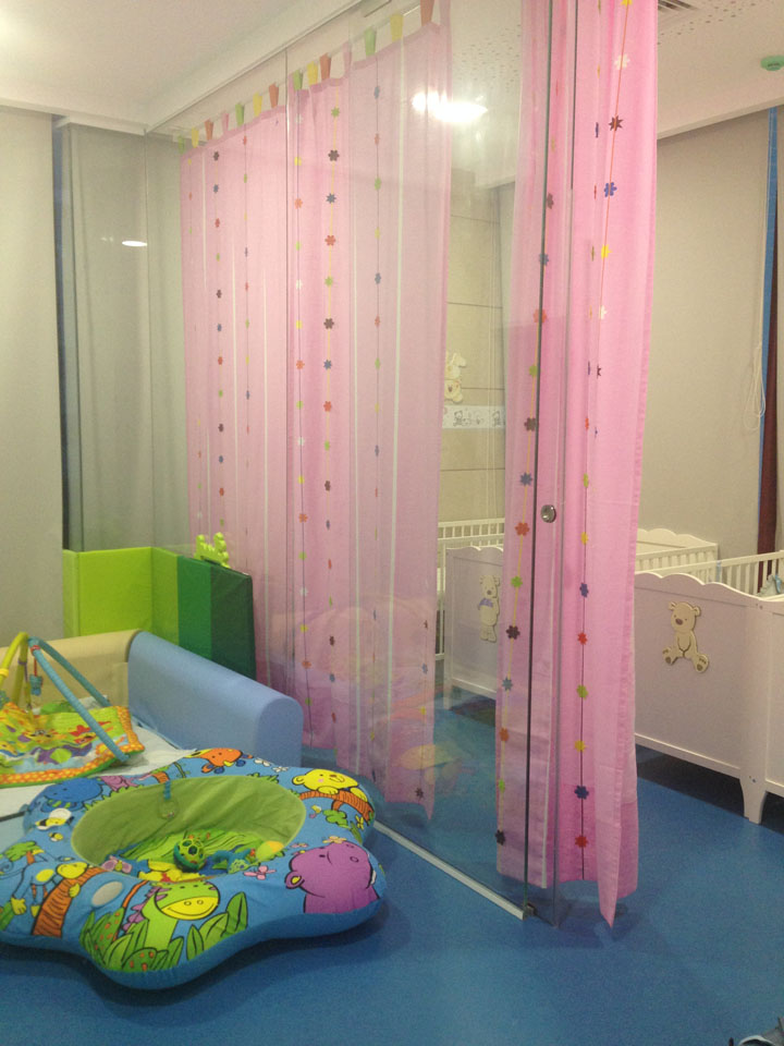 Preschool play area with colorful toys and pink curtains
