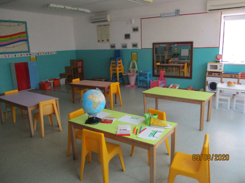 Preschool classroom with colorful tables, chairs, and learning materials