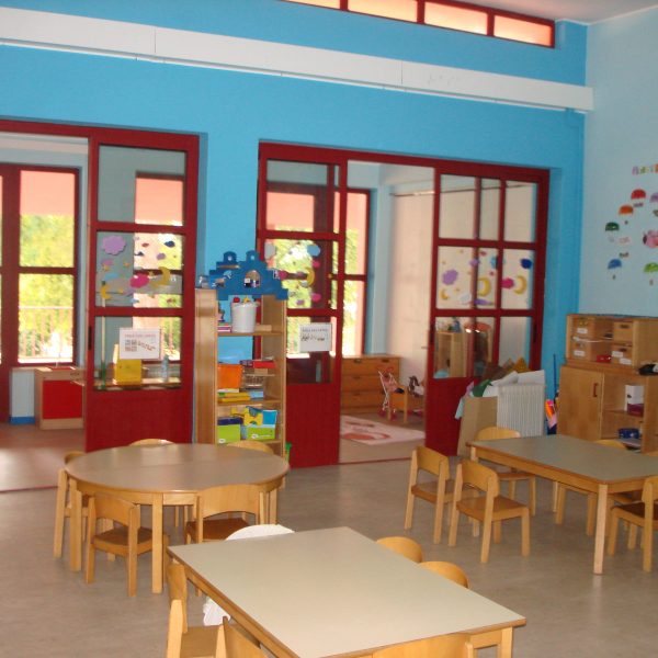 Preschool classroom with tables and chairs, and colorful walls