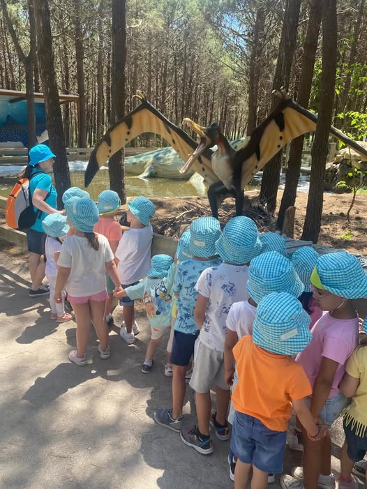 Preschool children on a field trip, looking at a dinosaur exhibit.