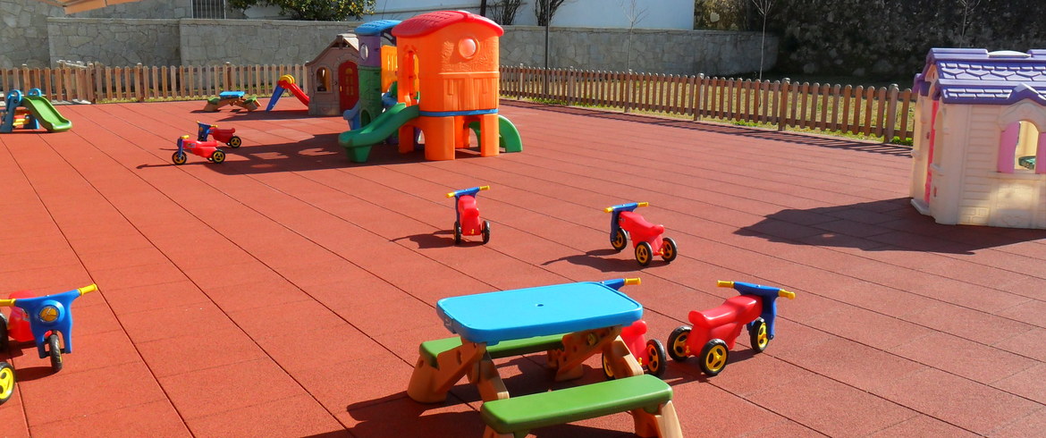 Preschool playground with colorful play structures and riding toys