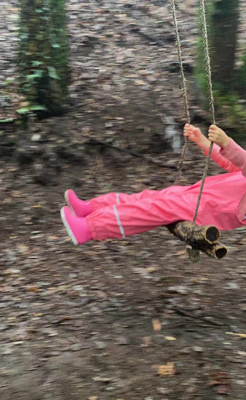 Child playing on a swing outdoors