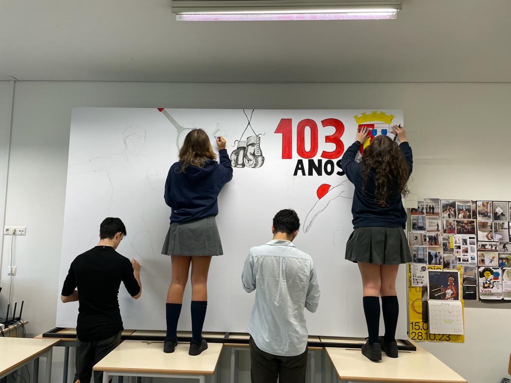 Students collaborate on a large artwork celebrating the school's 103rd anniversary.
