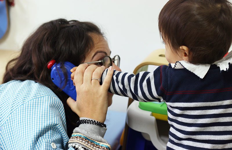 Teacher interacting with a toddler at Berçário e Creche de Espinho preschool