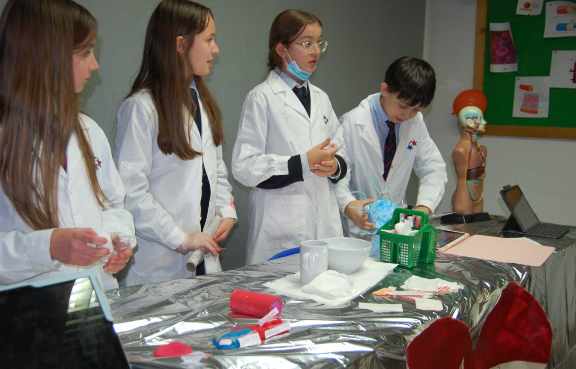 Students in lab coats conduct a science experiment