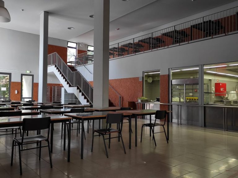 Empty cafeteria with tables and chairs, showing the school's interior