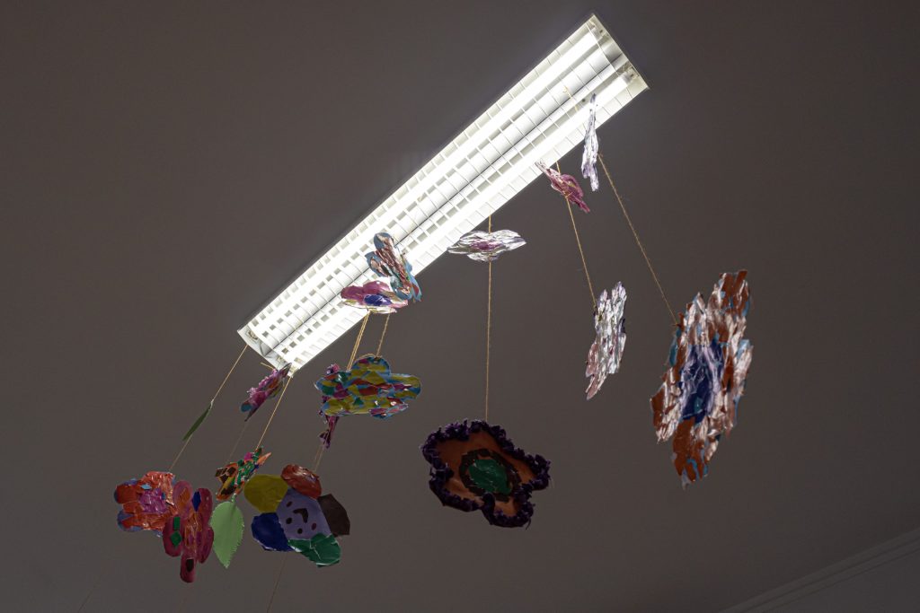 Colorful paper flowers hanging from the ceiling of a classroom