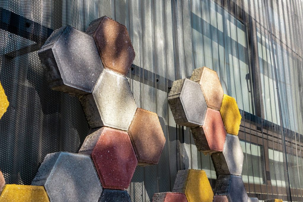 Hexagon-shaped paving stones on the exterior wall of Jardim de Infância de Lomar preschool.