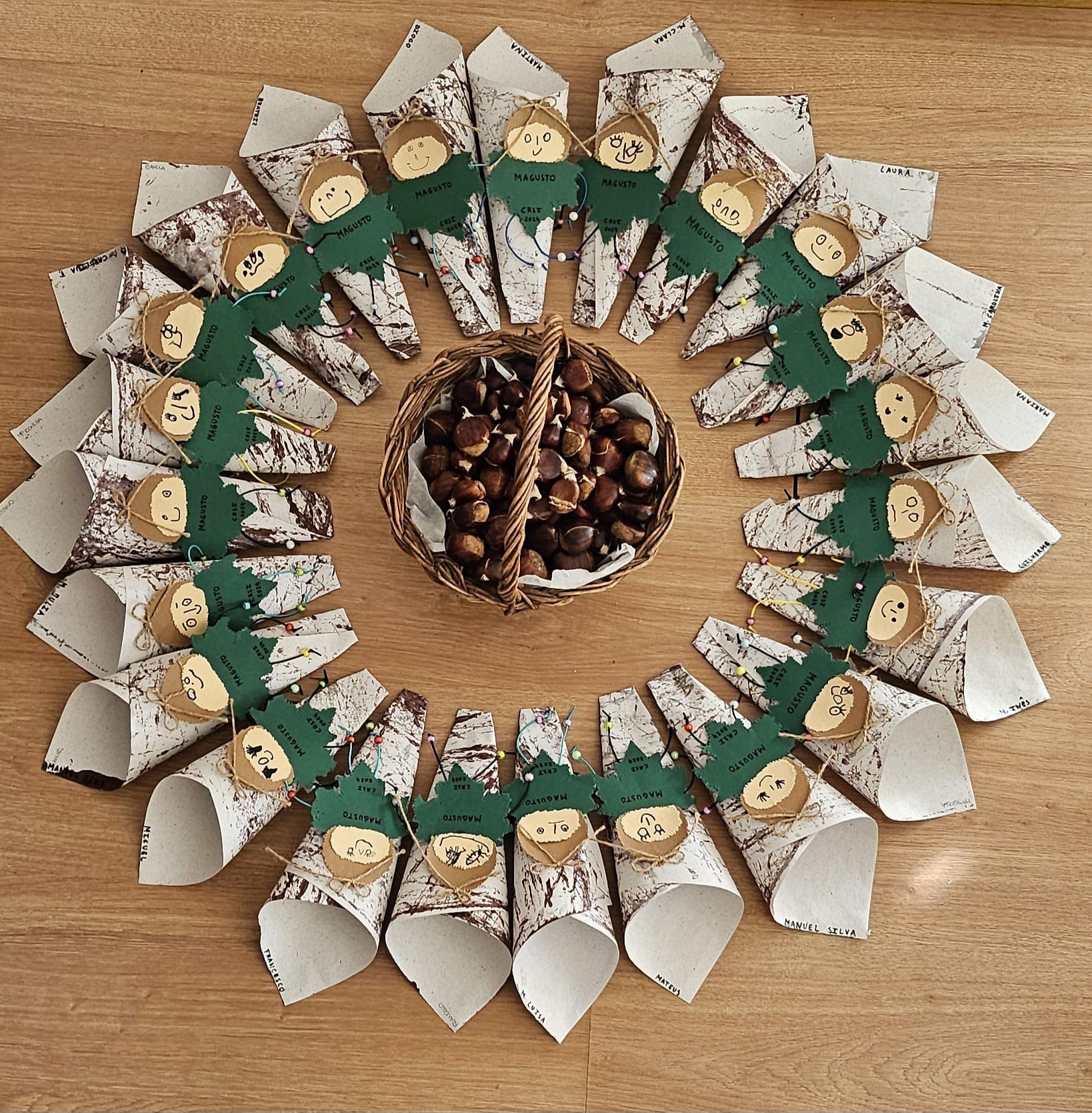 Preschool children's craft project: decorated paper cones filled with chestnuts, arranged in a circle around a basket of chestnuts.