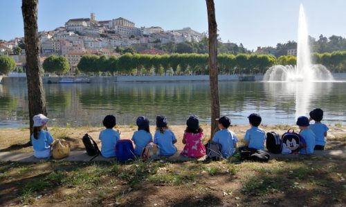 Preschool children on a field trip by the river, enjoying the view of the city