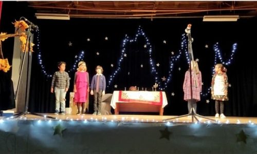 Preschool children in costumes performing a play on stage