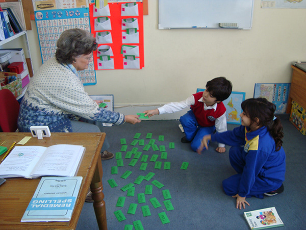 Preschool teacher helping children with a spelling game