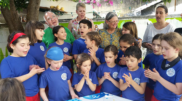 Preschool children in blue shirts singing together