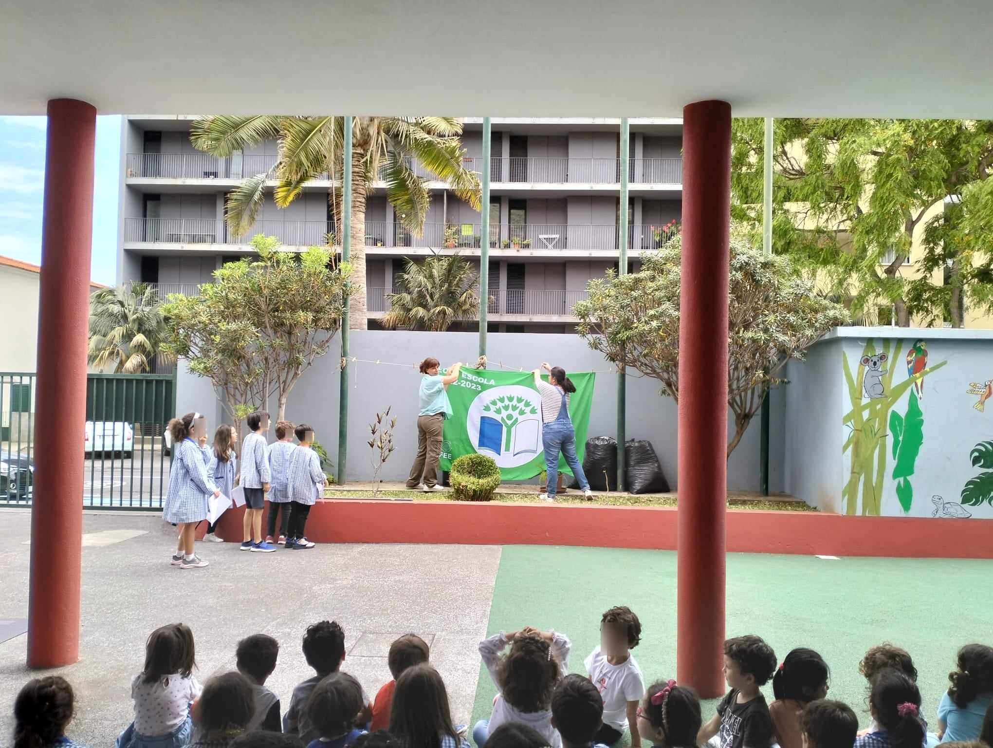 Preschool students attending an Eco-Schools Day event, raising a banner.