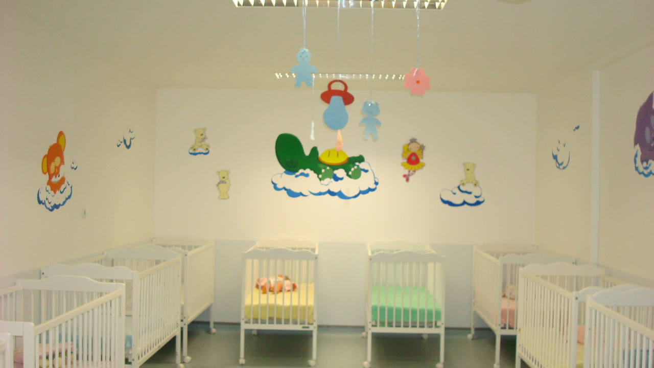 Nursery room with cribs and cartoonish wall decorations