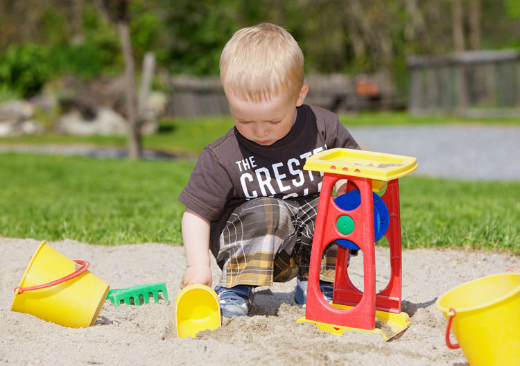 Preschool child playing with sand toys