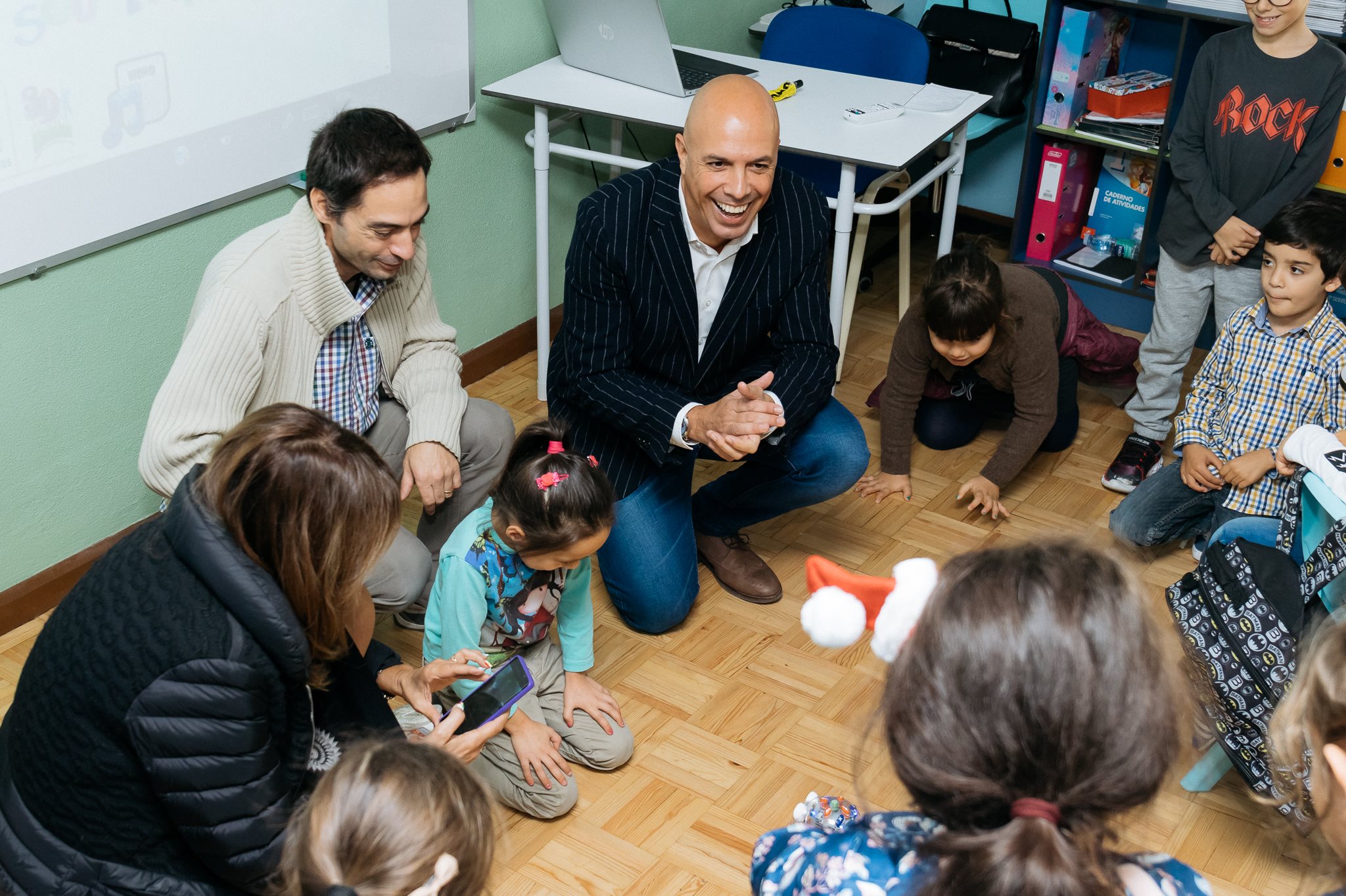 Preschool children and adults sitting on the floor playing a game