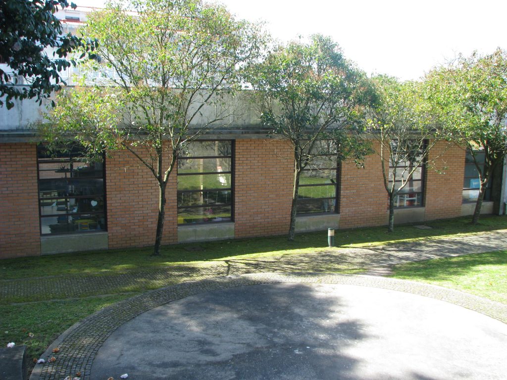 Exterior view of O Regaço preschool building, showing brick walls and large windows.