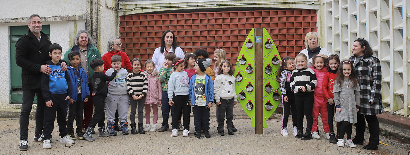Students and teachers of EB1/JI Megide school pose proudly in front of a newly installed vertical garden.