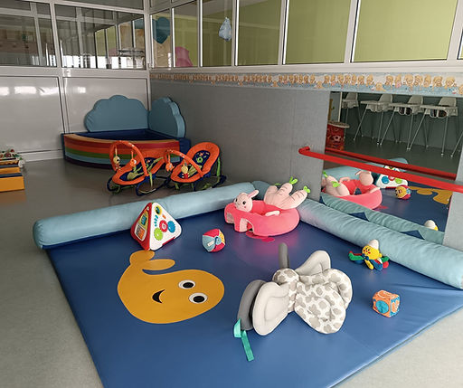 Preschool play area with colorful toys and soft mats