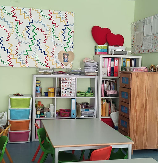 Preschool classroom with colorful storage shelves and a table