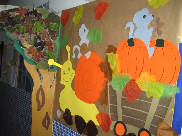 Autumn-themed classroom decoration with a snail, pumpkins, and squirrels.