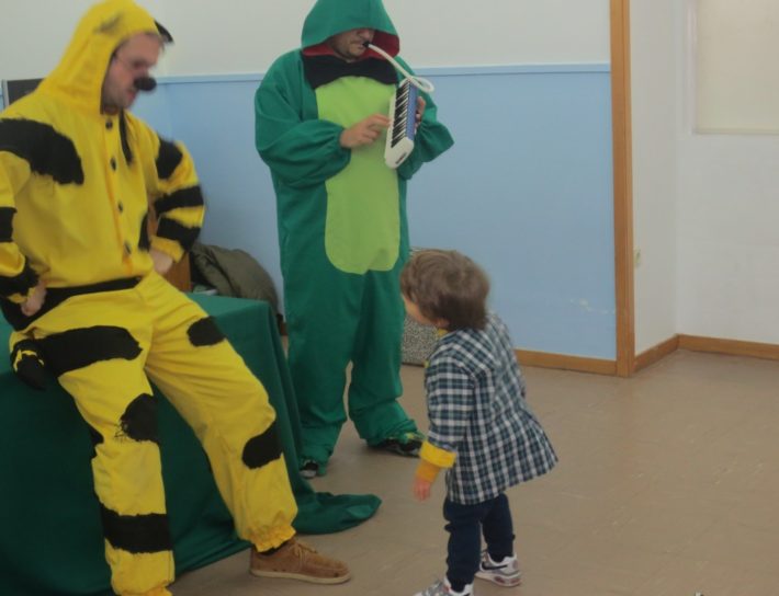 Preschool children and teachers in costumes playing music