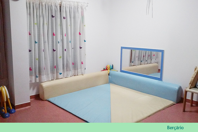 Preschool play area with soft mats and a mirror
