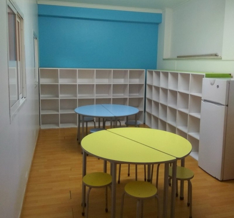 Preschool classroom with colorful tables and chairs, and plenty of storage