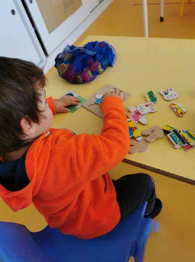 Preschool child playing with wooden animal puzzle