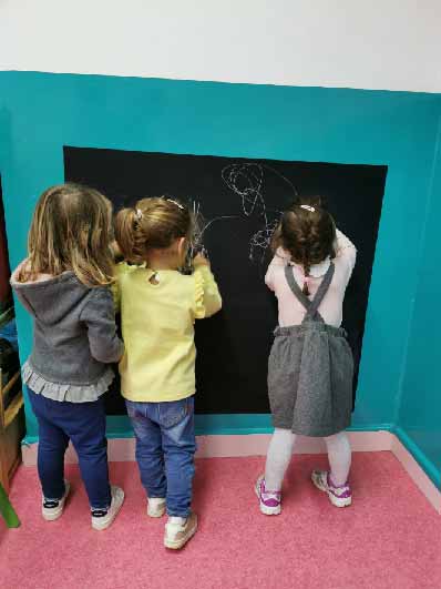 Preschool children drawing on a blackboard