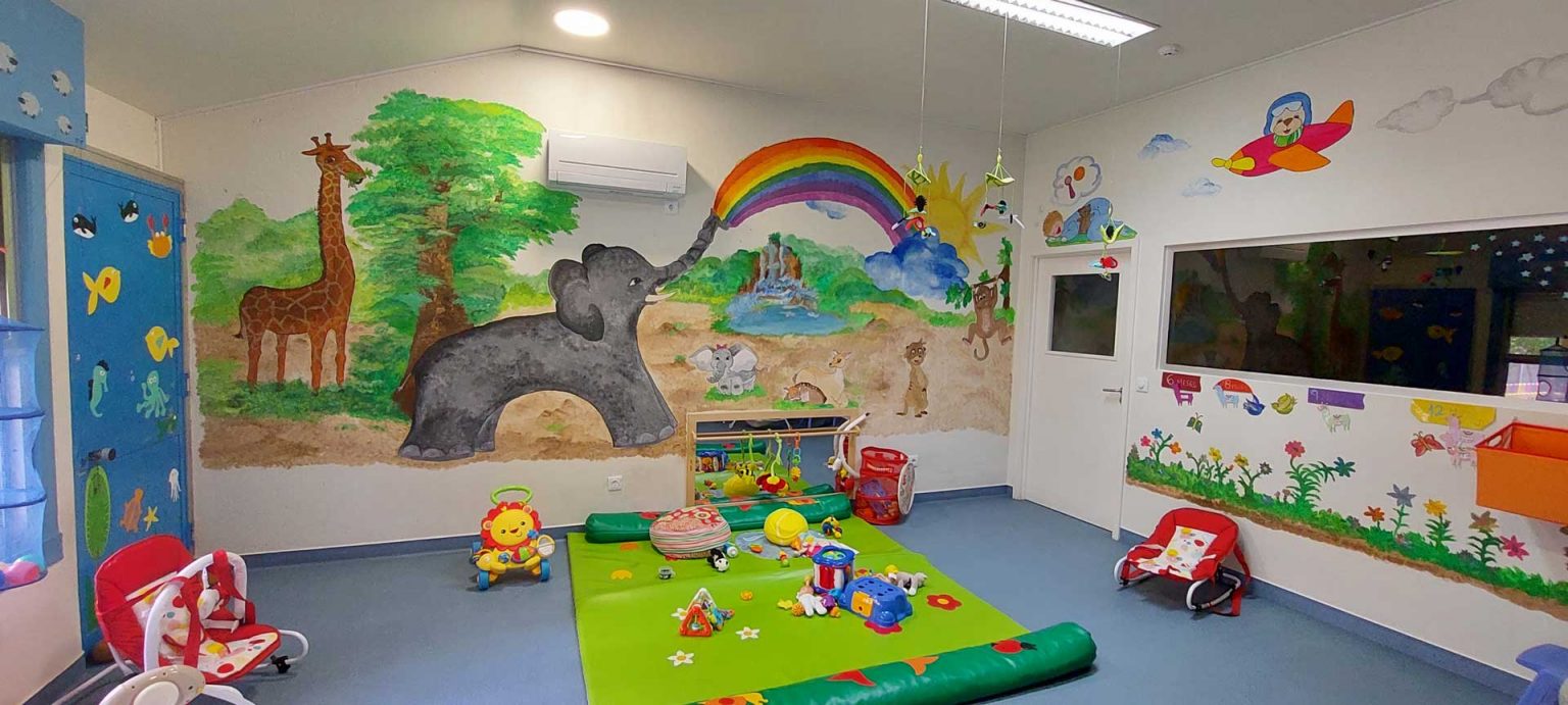 Preschool classroom with colorful murals and toys