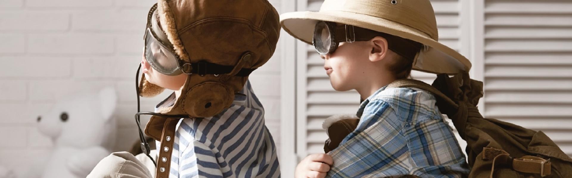 Two preschool children wearing pilot hats and goggles, ready for an adventure