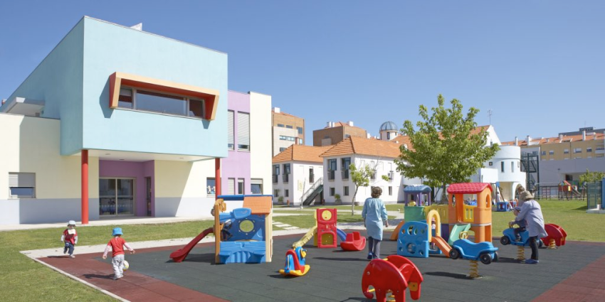 Preschool children playing on playground equipment at Casa Vera Cruz preschool.