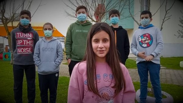 Casa Vera Cruz students wearing masks, standing outside the school building