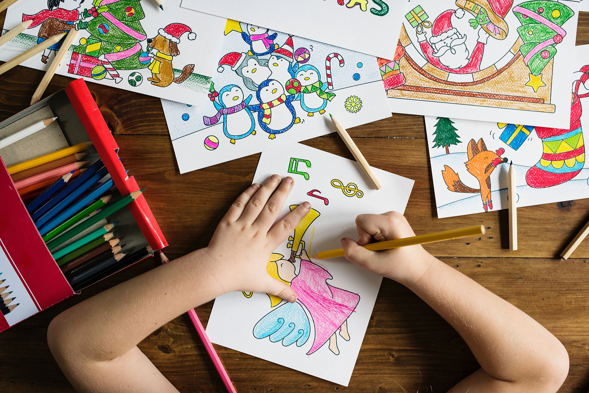 Preschool child coloring a picture of an angel playing a trumpet