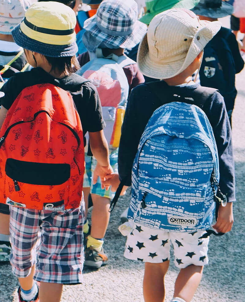Preschool children with backpacks walking together