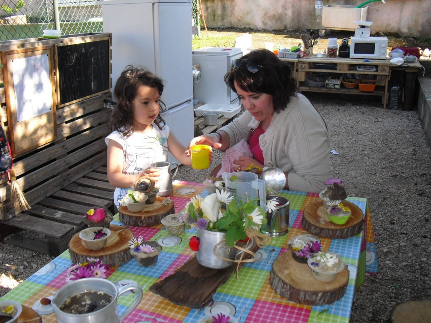 Preschool children engaged in a nature-themed activity, decorating cupcakes with flowers.