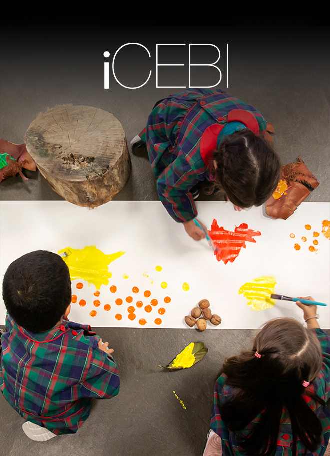 Preschool children painting with vibrant colors on a large sheet of paper.